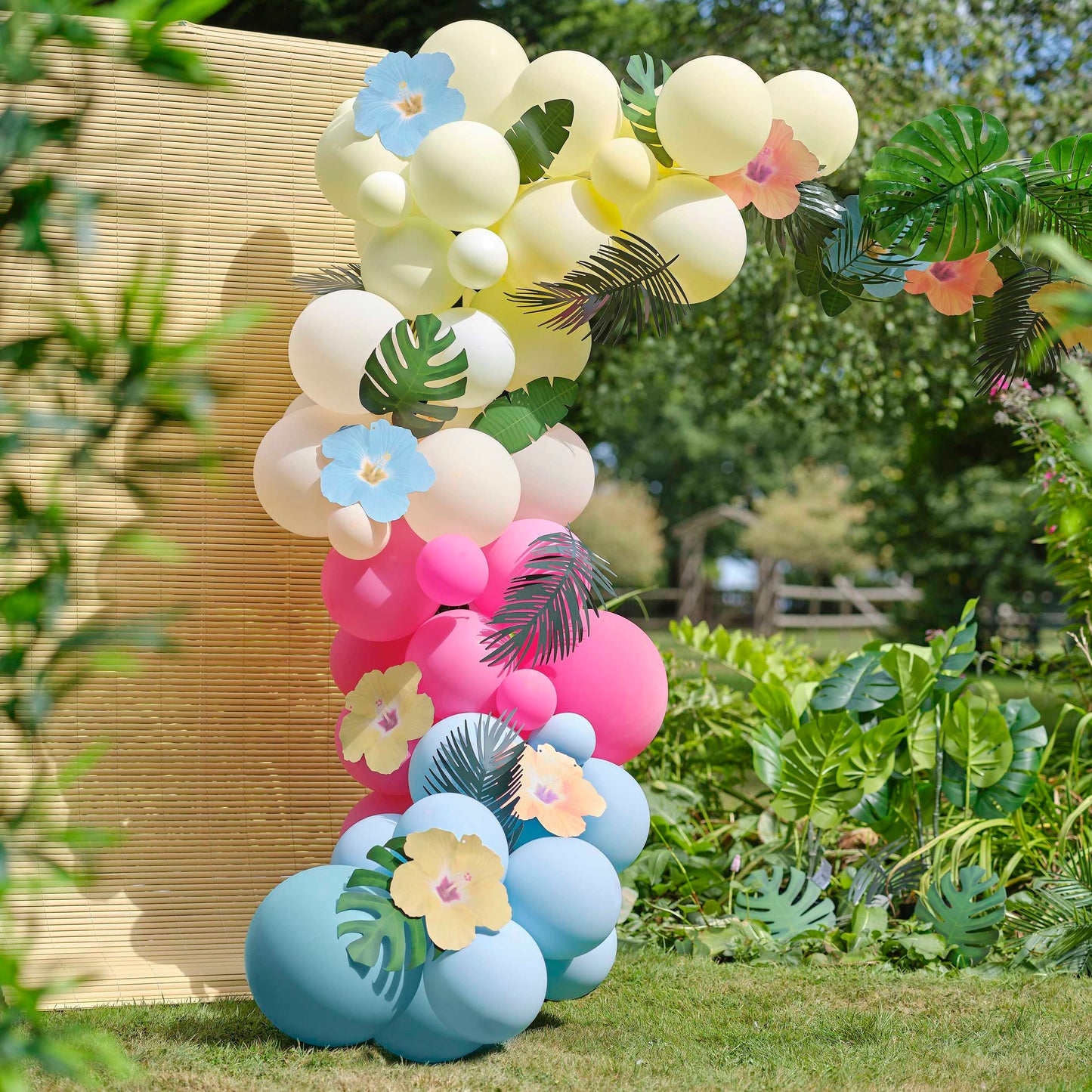 Blue, Pink, Green & Yellow Hawaiian Tiki Balloon Arch with Tropical Flowers and Foliage