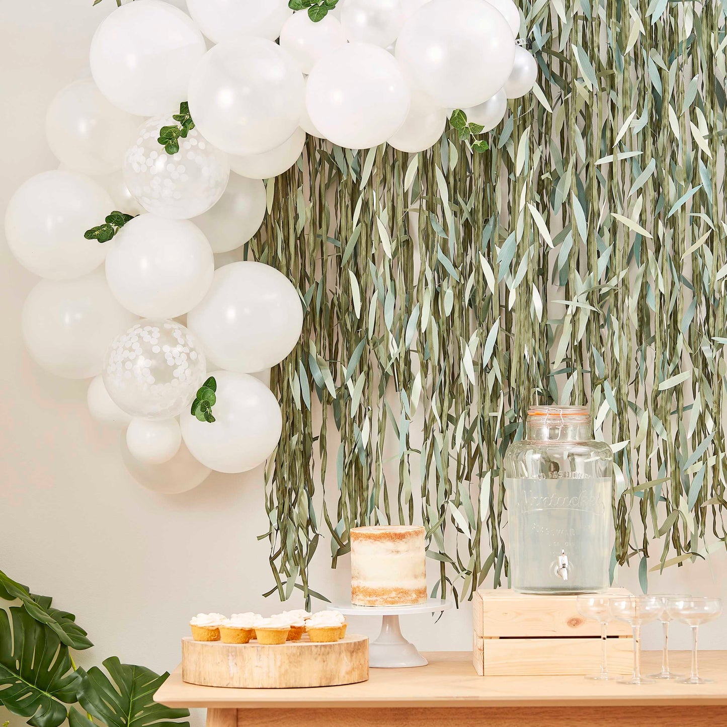 Arche de ballons blancs pour baby shower avec feuillage 